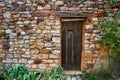 Ancient wooden door in a red ochre stone wall