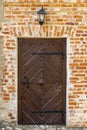 Ancient wooden door with street lamp on red brick wall Royalty Free Stock Photo