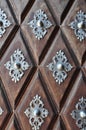 Ancient Wooden Gate with Metal decor on wooden cubes. Detail of a door in brown wood with silver motifs made with a lot of art