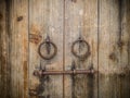 Ancient wooden gate with two door knocker rings and locks Royalty Free Stock Photo