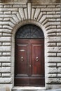 Ancient wooden portal with carved stone arch of an Italian medieval fortress