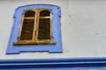 Ancient wooden window closed with blue frame on withe wall Royalty Free Stock Photo