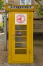 An ancient yellow Phone Booth in the city of Frankfurtm Germany