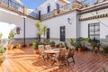 Andalusia patio with a wooden table and chairs, wall decorated with beautiful tiles and floor with brown porcelain paving with Royalty Free Stock Photo