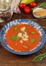 Cold tomato gazpacho soup with crackers and basil. In a vintage blue plate on a dark wooden background, close-up Royalty Free Stock Photo