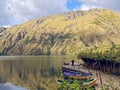 Andean mountains of the highlands of Peru, with lagoon, trees and boats.