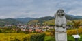 Andlau, Alsace village, vineyard, statue of monk carrying wine barrel Royalty Free Stock Photo