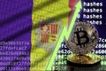 Andorra flag and rising green arrow on bitcoin mining screen and two physical golden bitcoins