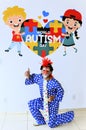 Joy with the clown Mineirinho who poses on the mural dedicated to World Autism Day