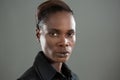 Androgynous man in black shirt posing against grey background Royalty Free Stock Photo