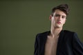 Androgynous man in blazer posing against green background Royalty Free Stock Photo