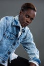 Androgynous man in denim jacket posing against grey background Royalty Free Stock Photo