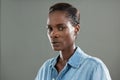 Androgynous man in denim shirt posing against grey background Royalty Free Stock Photo