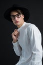 Androgynous man in hat posing with hand on collar Royalty Free Stock Photo