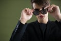 Androgynous man in sunglasses posing against green background Royalty Free Stock Photo