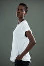 Androgynous man in white top posing against grey background Royalty Free Stock Photo