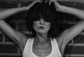 Androgyny female model in Heroin chic style near brick wall.