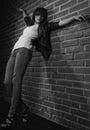 Androgyny female model in Heroin chic style near brick wall.