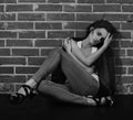 Androgyny female model in Heroin chic style near brick wall. Royalty Free Stock Photo