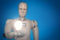 Android robot holding light bulb Royalty Free Stock Photo