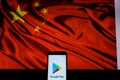 An android-smartphone that shows the Google Play store logo in front of the China flag