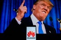 An android-smartphone that shows the Huawei logo in front of the picture of Donald Trump