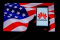 An android-smartphone that shows the Huawei logo in front of the USA flag