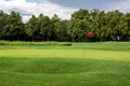 Andscape of a golf course with a green lawn and a hilly surface.