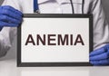 Anemia word on paper in doctor hand. Blood health concept