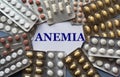 ANEMIA - word on a white sheet against the background of tablet plates