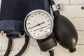 Aneroid sphygmomanometer with dial, bulb, air valve and a folded cuff, just after use to measure blood pressure in a patient with