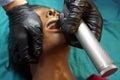 Anesthesiologist in a black gloves performing an orotracheal intubation on a simulation mannequin dummy during medical training