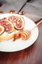 Ange view spelt sourdough toast with feta cheese spread, fresh figs with honey, and raw walnut. Vintage wooden table