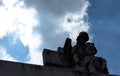 Angel and child sculpture looking down in low angle shooting with blue cludy misteryous sky Royalty Free Stock Photo