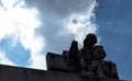 Angel and child sculpture looking down in low angle shooting with blue cludy misteryous sky Royalty Free Stock Photo