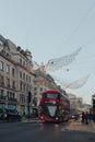 Angel Christmas lights on Regent Street, London, UK, red double decker bus on the road under