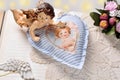 Angel figurine and handmade heart decor lying on opened book Royalty Free Stock Photo