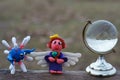 An angel figurine and a small glass globe. Next to the figure of the virus