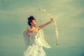 Angel girl with wings holding bow and arrow. Happy valentines day. Teen love and romance concept. Royalty Free Stock Photo