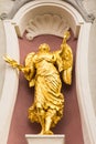 Angel golden statue on the facade of a church.