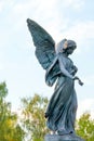 Angel Holds a Rose Over a Grave in a Cemetery