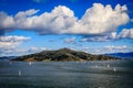 Angel Island with scattered sailboats and perfectly placed white clouds in a clear sunny day seen from Sausalito Royalty Free Stock Photo