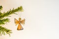 Angel made of straw, hanging in a green branch of a christmas tree