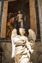 Angel statue in front of Jesus painting