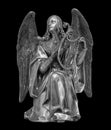 Angel statue isolated on black background with clipping path. White stone sculpture of praying cherub