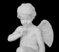 Angel statue isolated on white background. White stone sculpture of praying cherub isolated photo with clipping path