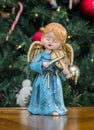 Angel statue playing violin by a Christmas tree Royalty Free Stock Photo