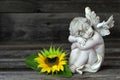 Angel and sunflower on wooden background Royalty Free Stock Photo