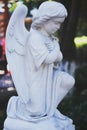 Angel vintage sculpture. Stone sculpture in the shape of an angel. Sculpture of an angel bowed his head at the entrance.