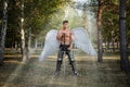 Angel warrior, a bodybuilder in plate armor on his legs with wings behind his back, stands in the beam of light Royalty Free Stock Photo